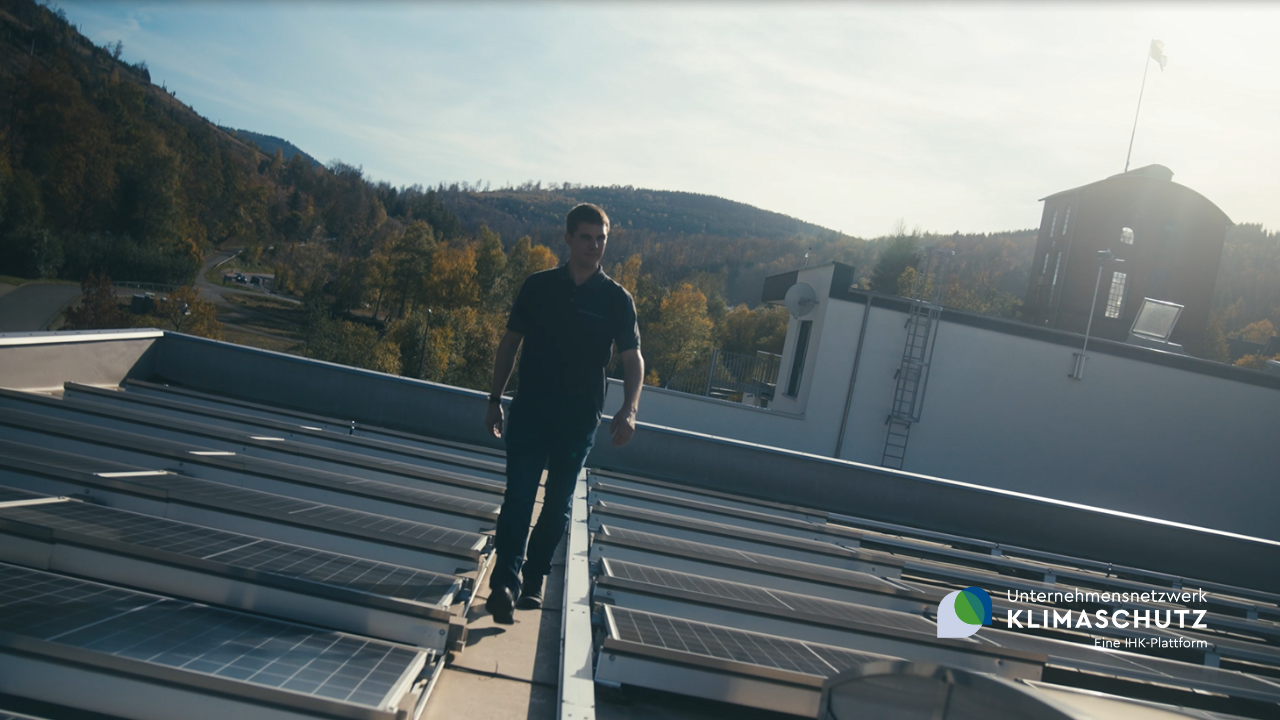 Das Bild zeigt das Dach der Condensator Dominit GmbH mit erneuerbaren Energien und einem Mitarbeiter