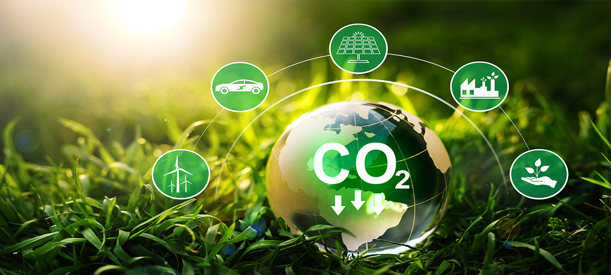 Ein Wassertropfen mit CO2-Symbol auf einer grünen Wiese. Um den Wassertropfen gruppieren sich weitere, mit dem Klimaschutz assoziierte Symbole.
